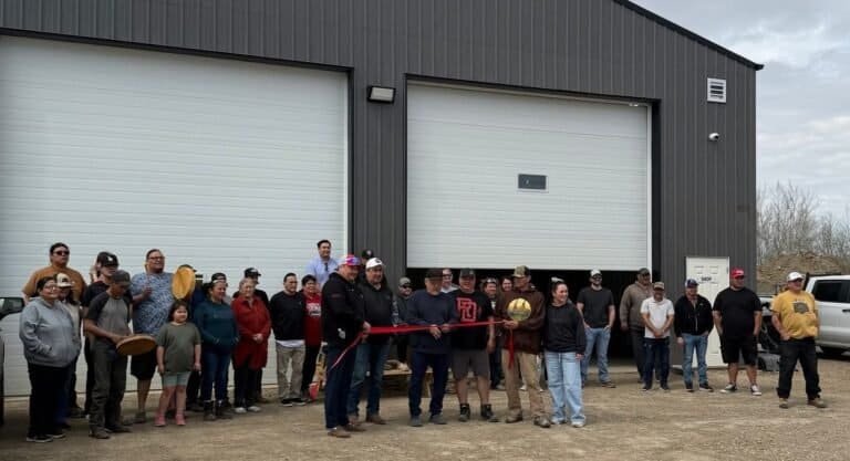 A crowd gathered for the ribbon cutting at the new RPCN Operation and Maintenance Shop, in front of its two big white bay doors